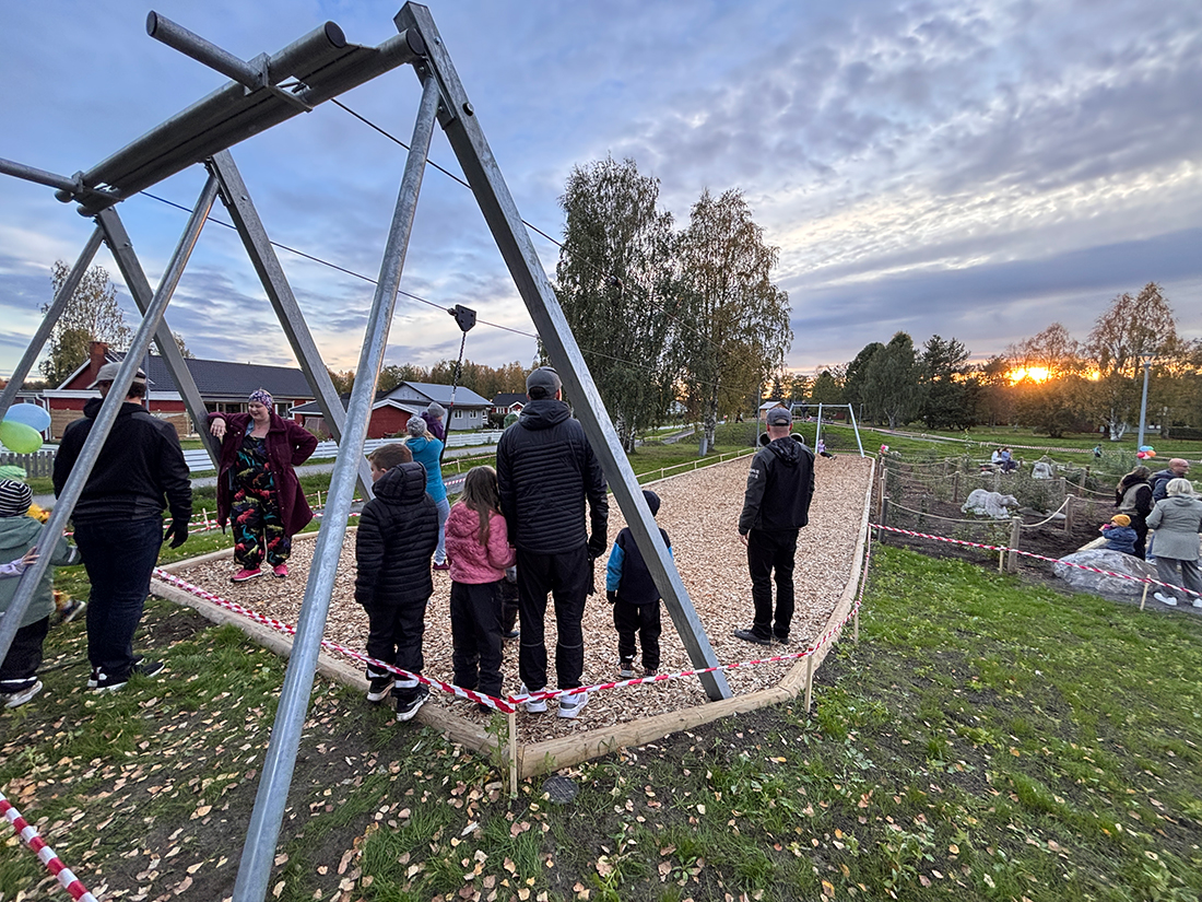 Lek- och klättertorn med rutschkana och gungor. En liten karusell. Ytan är sand